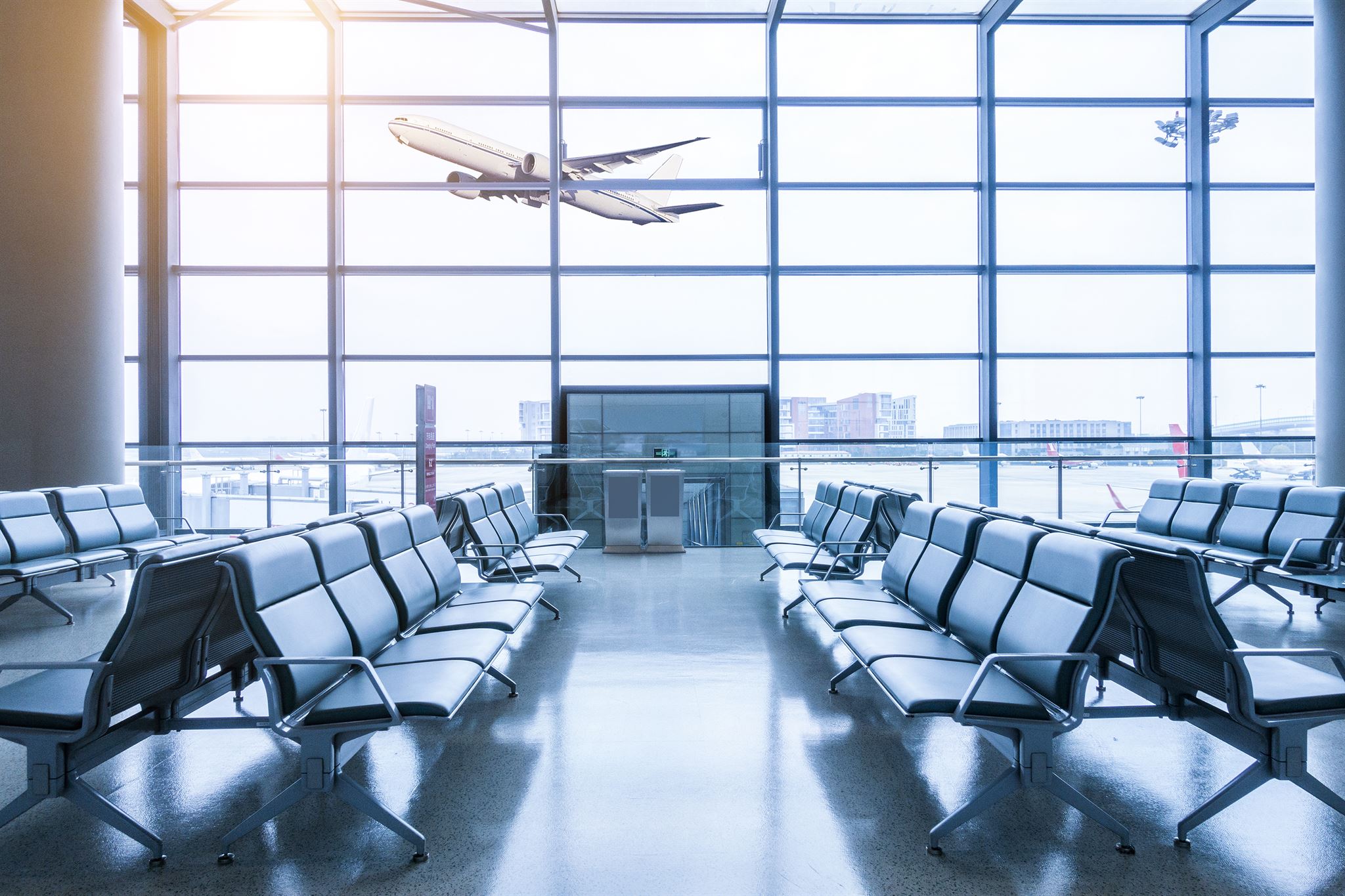 Plane-flying-in-front-of-an-empty-airport-lounge
